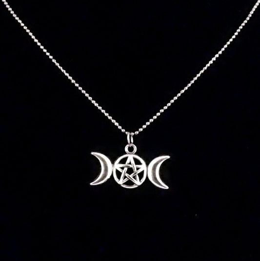 A close up image of the triple goddess pentagram necklace on a black background from Uncorked & Bottled Up